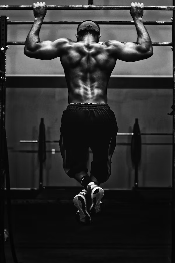 a man doing pull-ups at a gym
