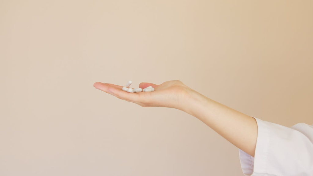 An image of a person holding pills in hand