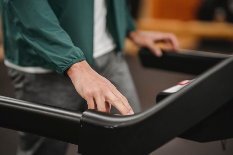 A person pressing buttons on a treadmill